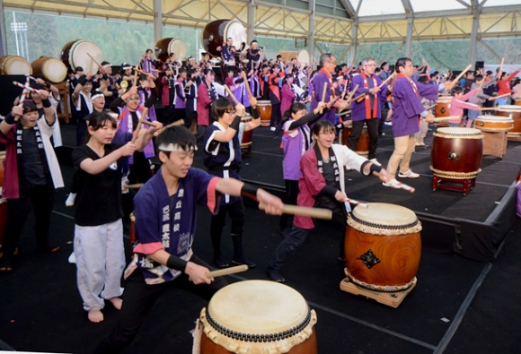 町民も加わって１００人以上で展開したオープニングの合同演奏＝東栄町本郷の東栄ドームで