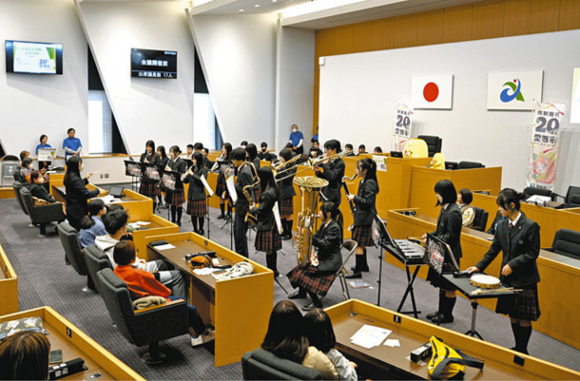 議場の真ん中で演奏する清林館中・高の吹奏楽部＝愛西市議会で