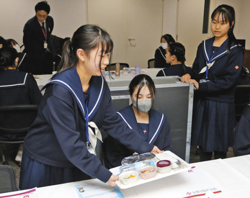 機内食の配膳を体験する生徒＝常滑市の名古屋エアケータリングで