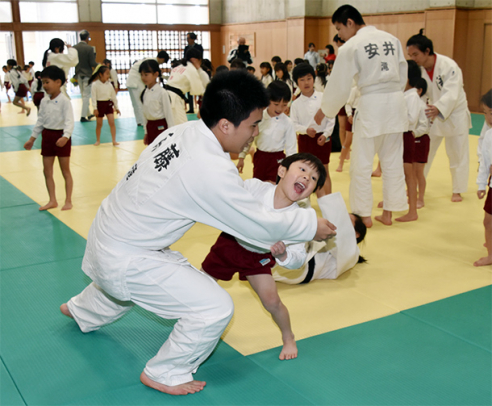 柔道部員を相手に投げの練習をする園児たち＝江南市の滝学園柔道場で