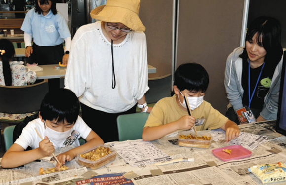 発掘体験で恐竜について学ぶ子どもら=長久手市の愛・地球博記念公園で