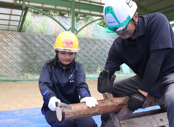 のこぎりでヒノキを切る生徒＝熊野市井戸町の海ひかりで