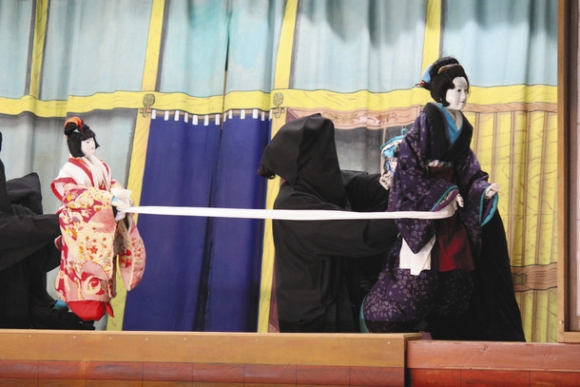 滑らかに人形を操る黒子姿の人形遣いら＝志摩市阿児町安乗の安乗神社で