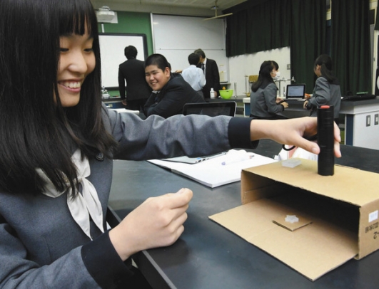 樹脂に紫外線を当てる実験に取り組むサイエンスクラブ部長の生徒＝桑名市の津田学園中で