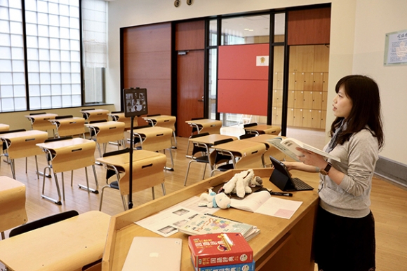 １人きりの教室で、タブレット端末に向かって国語の授業をする教諭＝名古屋市昭和区の名古屋国際中・高で