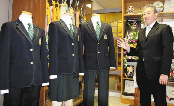 ４月から導入される制服を紹介する下村校長。女子の制服はスカート（中）とスラックス（左）の２種類ある