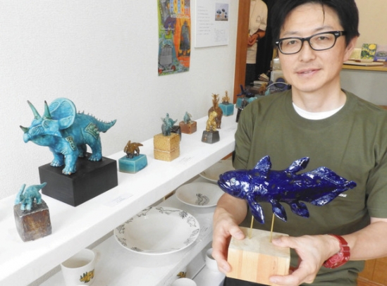 恐竜やシーラカンスなどを題材にした楽しい陶芸作品を出展したエムラさん＝千種区東山元町のギャラリー３６６で
