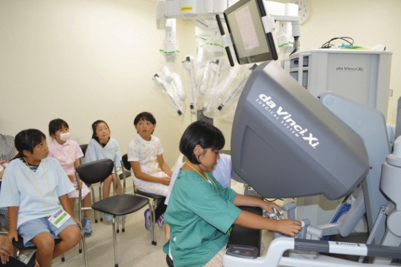 手術支援ロボット「ダビンチ」のシミュレーターを体験する参加者＝豊明市の藤田医科大で