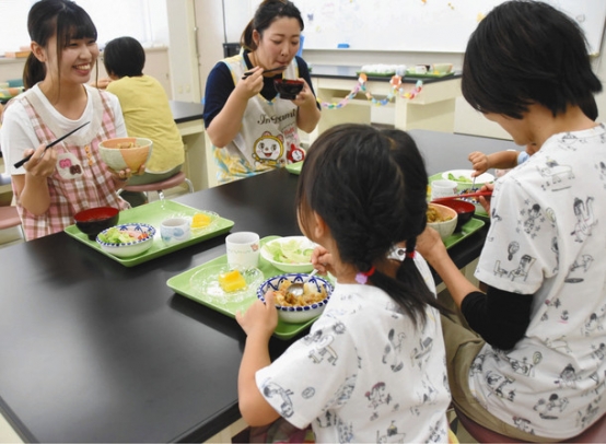学生らと食事を楽しむ子どもたち＝岡崎市中町の岡崎女子大で