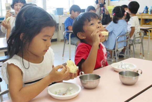 口いっぱいに米粉蒸しパンをほおばる園児たち＝江南市小杁町の小鹿保育園で