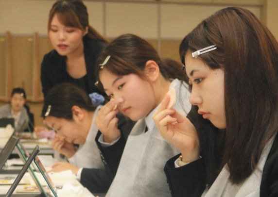 教わった化粧法を実践する学生たち＝大垣市西之川町の大垣女子短大で