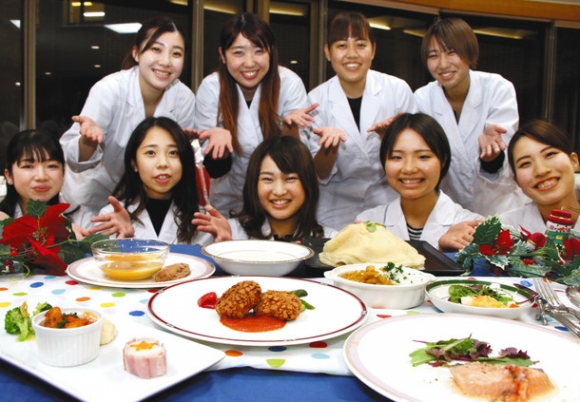 クリスマスパーティーで提供する料理をＰＲする学生たち＝稲沢市稲葉の愛知文教女子短大で