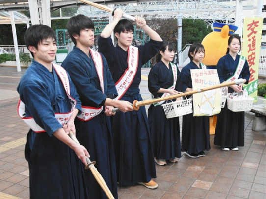 竹刀を構え「ながら運転絶対しない」と呼び掛ける剣道部員たち＝名鉄豊田市駅前で