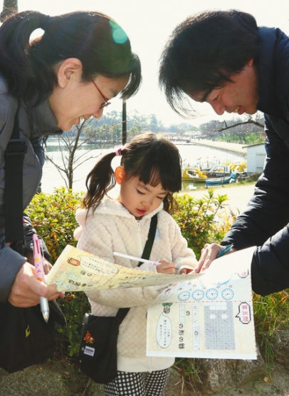 クイズに答えながら市内を探索する参加者＝津島市の天王川公園で