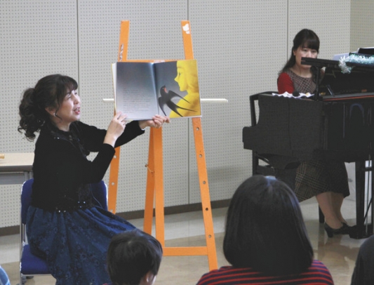 加藤さん（右）のピアノ演奏に合わせ、絵本を読み語る真下さん＝一宮市尾西生涯学習センターで