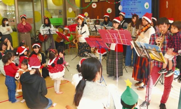 学生と一緒にクリスマスソングを演奏する園の利用者ら＝稲沢市稲葉２の愛知文教女子短大で