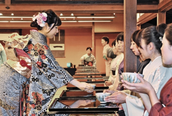 振り袖姿でお茶を振る舞う学生（左）＝名古屋市熱田区の熱田神宮で