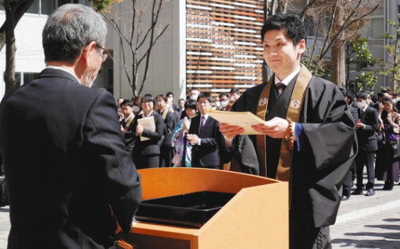 証書を受け取る卒業生代表の荒川雄真さん＝名古屋市中村区の同朋大で
