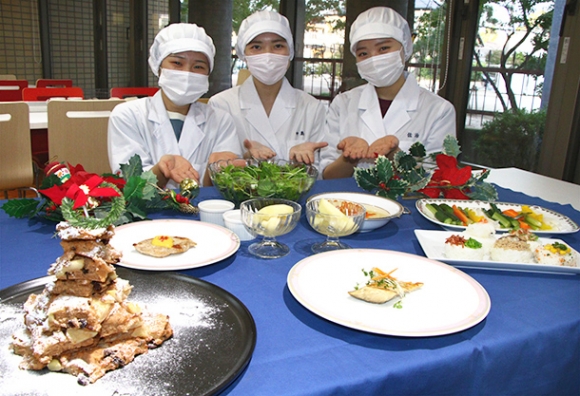 テークアウトで提供する料理をＰＲする学生たち＝稲沢市稲葉２の愛知文教女子短大で