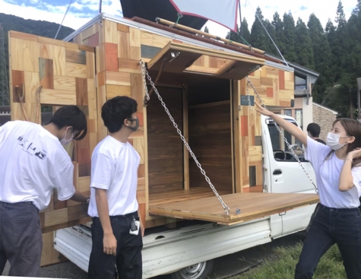 軽トラック荷台の「モバイルハウス」を披露する学生ら＝白山市尾添で