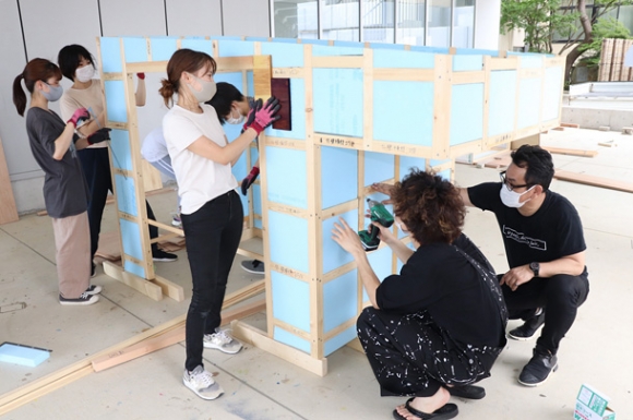 宮下智裕准教授（右）に教わりながらモバイルハウスを組み立てる学生＝野々市市の金沢工業大で
