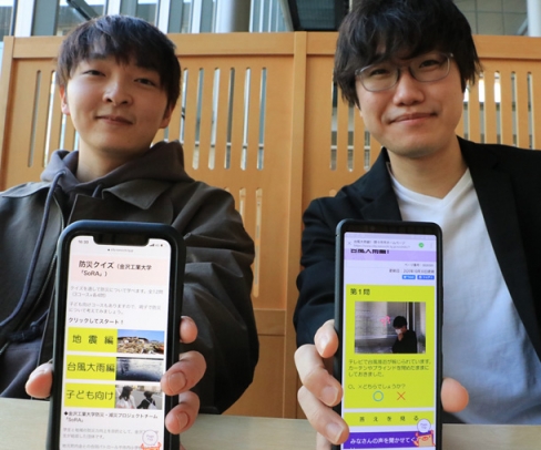 スマートフォンで参加できる防災クイズを作った学生団体の浜辺圭介代表（左）と吉田晴輝さん＝野々市市役所で