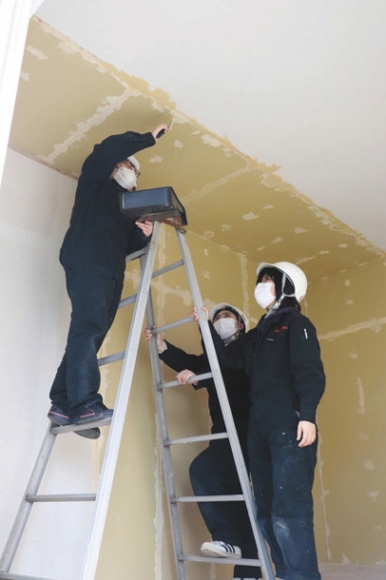 作業着姿で天井の塗装に取り組む岐阜女子大の学生ら＝山県市佐賀で