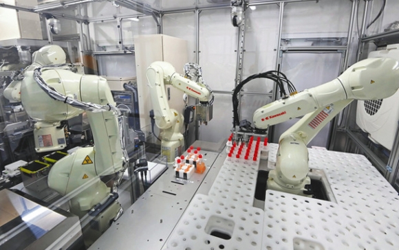 藤田医科大に設置されたコンテナ内で検体を処理するロボット＝４日午後、愛知県豊明市で（木戸佑撮影）