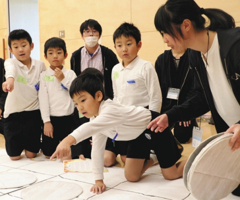 金沢工業大生たちの「防災・減災プロジェクトＳｏＲＡ」が企画したイベントで、防災ゲームに熱中する子どもら＝２０１９年１１月、石川県野々市市の富奥防災コミュニティセンターで