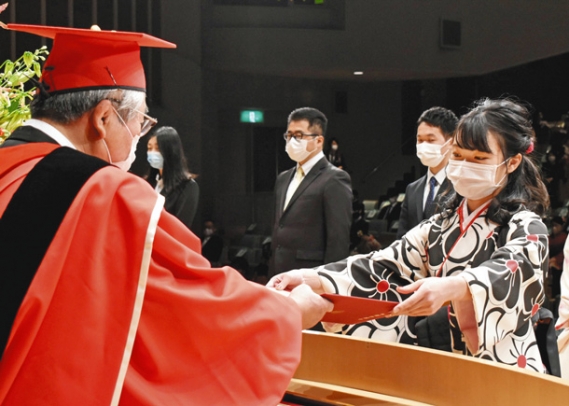 古田学長（左）から卒業証書を受け取る卒業生＝岐阜市の長良川国際会議場で