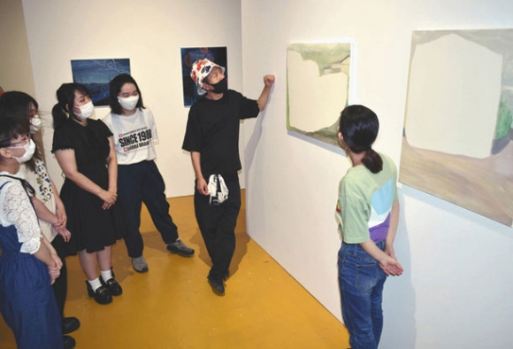 出展した学生たちと展示作品に見入る鷲尾さん（右から２人目）＝中区錦２の長者町コットンビルで