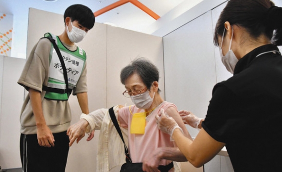 高齢者のワクチン接種をサポートする大学生（左）＝名古屋市中村区の愛知大名古屋キャンパスで