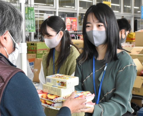 地域住民から食料品を受け取る学生ら＝北名古屋市弥勒寺西のピアゴ西春店で