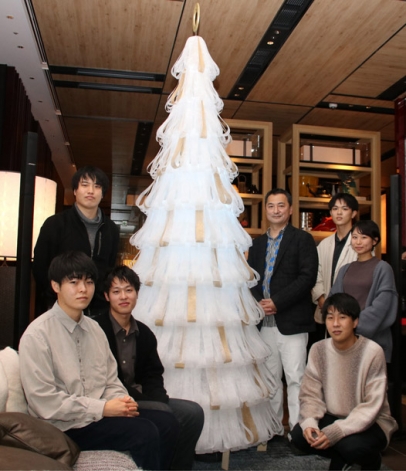 クリスマスツリーを囲む竹内申一教授（右から４人目）と学生＝金沢市広岡のハイアットセントリック金沢で