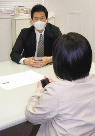 研究に参加する女性から、アプリの使い勝手を聞く後藤客員研究員（左）＝昭和区の名古屋大医学部で