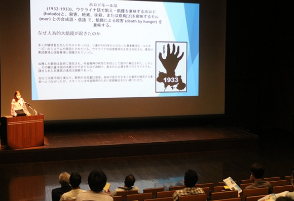 日本福祉大の学生を前に講演する川口さん（左奥）＝東海市の市芸術劇場で