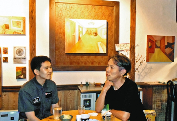 作品を展示し、講師の鷲尾さん（右）と歓談する渡辺さん＝北区大杉３の「ケケ」で