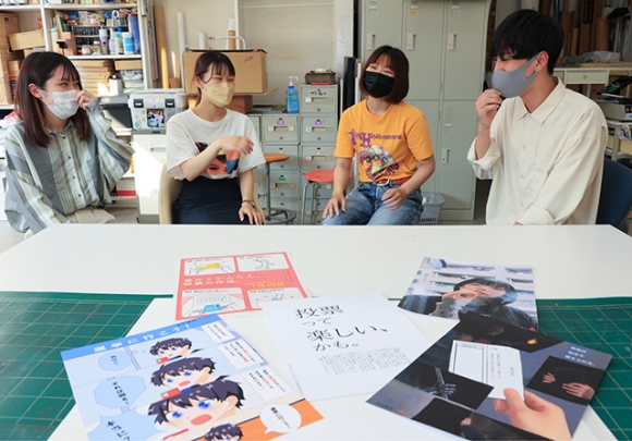 同世代向けに投票を呼びかけるポスターを制作した（左から）弓矢さん、山崎さん、炭谷さん、椙江さん＝北名古屋市の名古屋芸術大で
