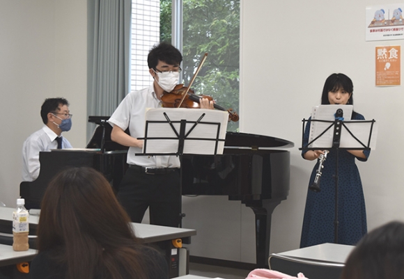 学生たちの前で演奏を披露する（右から）マソンさん、大倉さん、石山教授＝豊明市の桜花学園大で