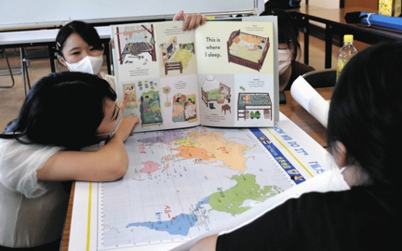 英語と日本語で絵本の読み聞かせをする学生たち＝日進市の市にぎわい交流館で