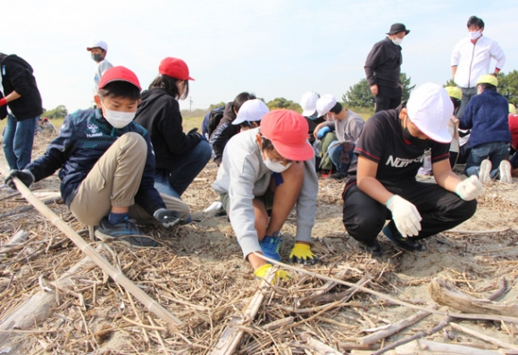 プラスチックごみを探す児童ら＝三重県四日市市の吉崎海岸で