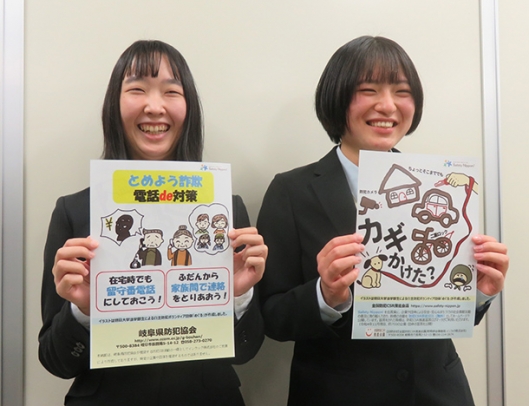 自身がデザインしたチラシを手に取る五島さん（左）と松井さん＝岐阜市薮田南の県防犯協会で