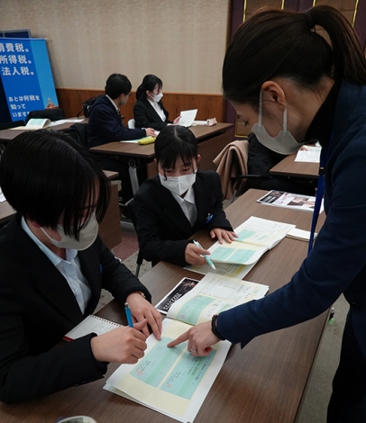 模擬税務調査で、不審な領収書を見抜く着眼点を教わる学生（左）＝名古屋市中区の名古屋国税局で