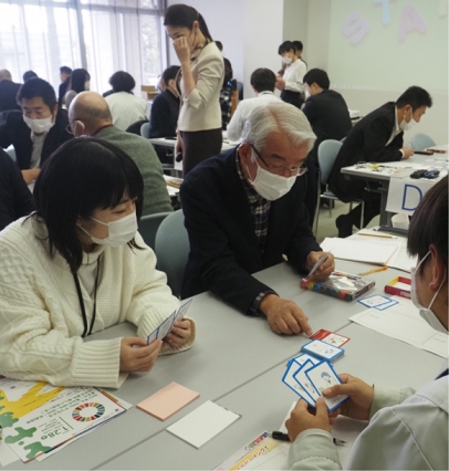 カードゲームを使って課題解決法を話し合う参加者＝魚津市の新川文化ホールで
