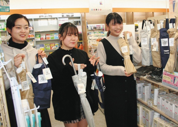 マイ傘袋「Ｕ－Ｂａｇ」を商品化し、店頭で笑顔を見せる金城学院大の３人＝名古屋市守山区の同大生協ショップで