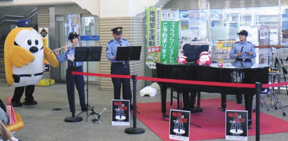 ストリートピアノを活用し、犯罪被害防止などを呼びかける警察官ら＝伊勢市の近鉄宇治山田駅で