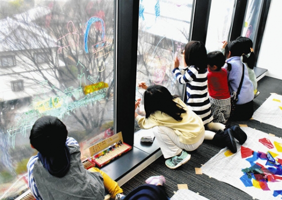 夢中になってガラス面に絵を描く子どもたち＝名東区平和が丘３の愛知東邦大で