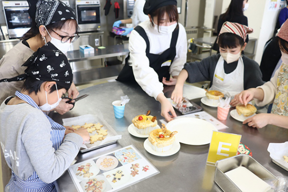 トナカイの顔をあしらったポットパイやクッキーなどを作る親子ら＝日進市の愛知学院大で