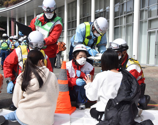 負傷者への対応を訓練する救急隊員役の学生（中央）ら＝守山区の金城学院大で