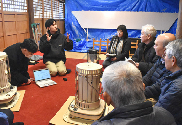 神社関係者に調査結果を報告する学生たち（左側）＝能登町宇出津で